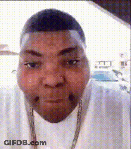 A Man Wearing A White Shirt And A Gold Chain Is Making A Face . GIF