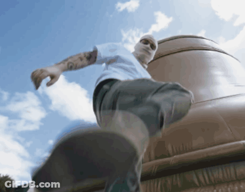 A Man Wearing A White Shirt And A Mask Is Walking GIF