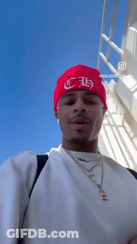 A Man Wearing A White Shirt And A Red Beanie With The Letter H On It GIF