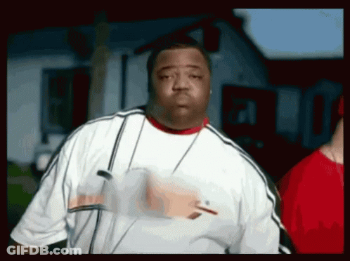 A Man Wearing A White Shirt And A Red Collar Is Standing In Front Of A House . GIF