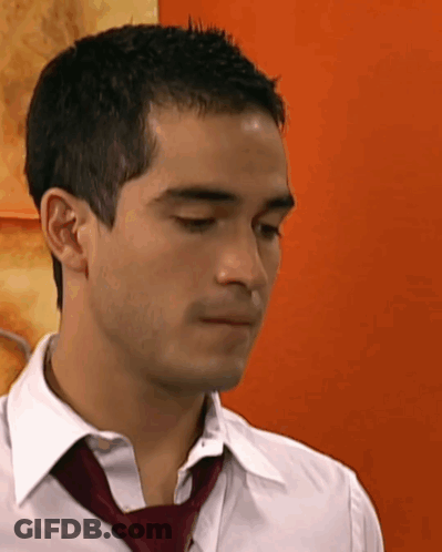 A Man Wearing A White Shirt And A Red Tie Looks Down GIF