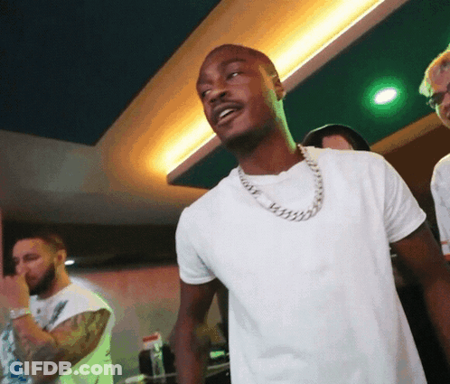 A Man Wearing A White Shirt And A Silver Chain Around His Neck GIF