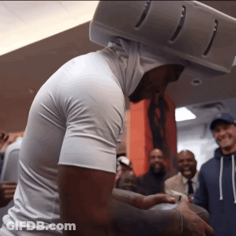 A Man Wearing A White Shirt And A White Helmet Stands In Front Of A Crowd GIF