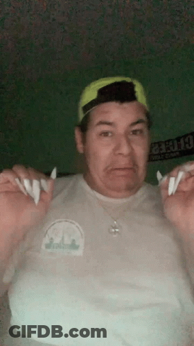 A Man Wearing A White Shirt And A Yellow Hat Is Holding Something In His Hands . GIF
