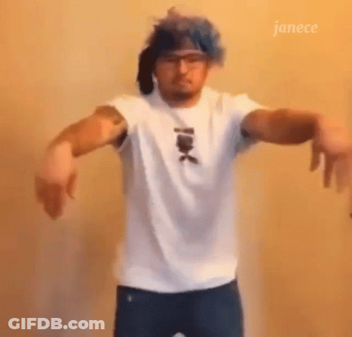 A Man Wearing A White Shirt And Blue Hair Is Dancing . GIF
