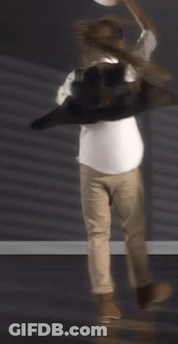 A Man Wearing A White Shirt And Khaki Pants Is Dancing GIF