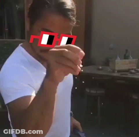 A Man Wearing A White Shirt And Red Sunglasses With The Letter H On The Lens GIF