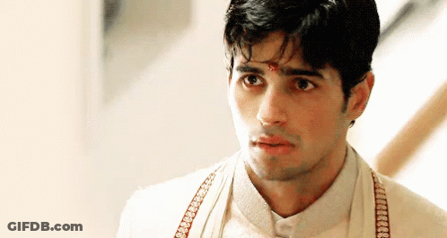 A Man Wearing A White Shirt And Suspenders Is Looking At The Camera With A Serious Look On His Face . GIF