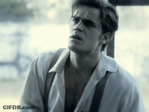 A Man Wearing A White Shirt And Suspenders Looks To The Side GIF