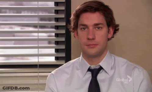 A Man Wearing A White Shirt And Tie Is Sitting In Front Of A Window With Blinds . GIF
