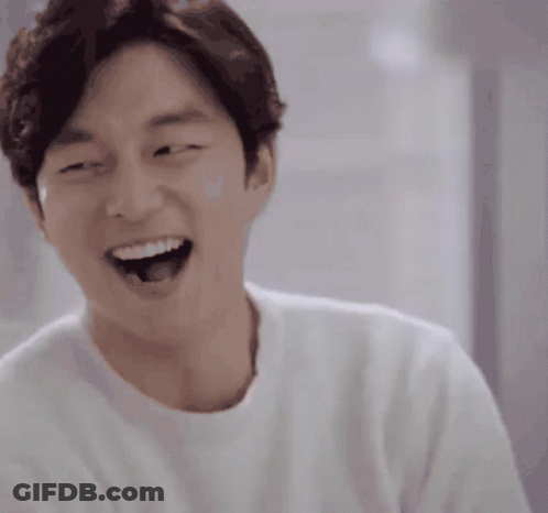 A Man Wearing A White Shirt Is Laughing With His Mouth Wide Open GIF