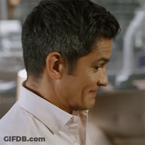 A Man Wearing A White Shirt Is Making A Funny Face GIF