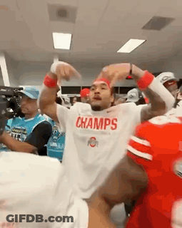A Man Wearing A White Shirt That Says Champs Is Dancing In A Locker Room GIF