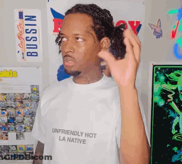 A Man Wearing A White Shirt That Says `` Unfriendly Hot La Native '' GIF