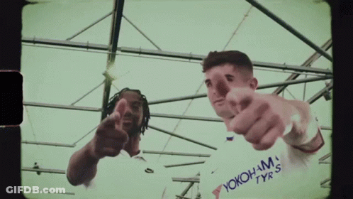A Man Wearing A White Shirt That Says Yokohama Tyres Points At The Camera GIF