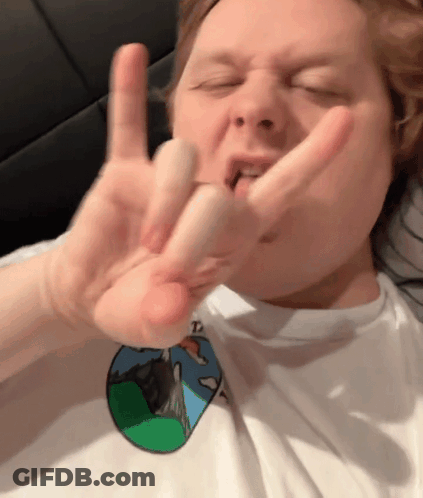 A Man Wearing A White Shirt With A Picture Of A Mountain On It Is Making A Funny Face GIF