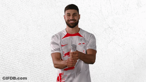 A Man Wearing A White Shirt With A Red Bull Logo On It GIF