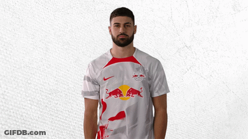 A Man Wearing A White Shirt With A Red Bull On The Front GIF