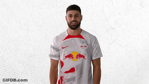 A Man Wearing A White Shirt With A Red Bull On The Front GIF
