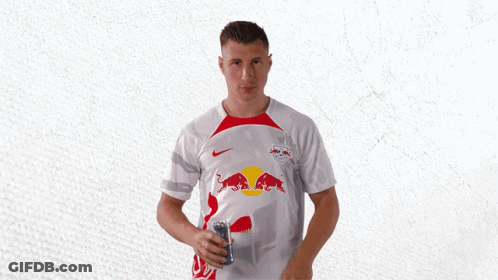 A Man Wearing A White Shirt With Red Bulls On The Front GIF