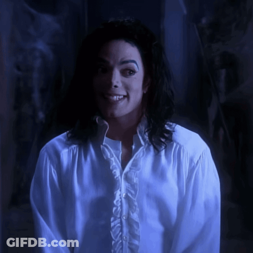 A Man Wearing A White Shirt With Ruffles On The Sleeves Smiles GIF