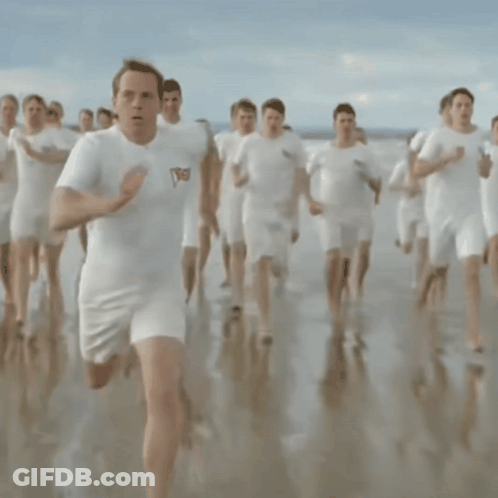 A Man Wearing A White Shirt With The Word England On It Is Running On The Beach GIF