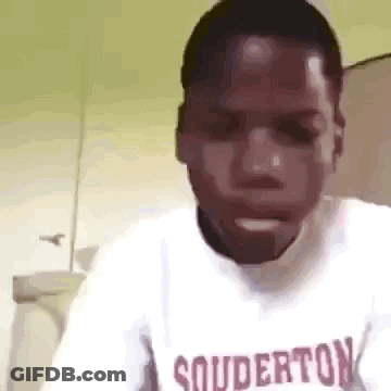 A Man Wearing A White Shirt With The Word Souderton On It . GIF