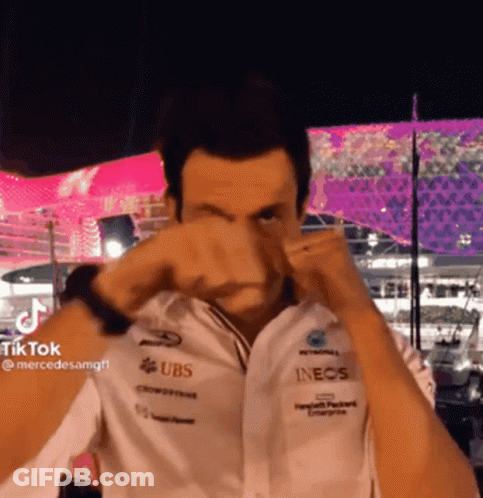 A Man Wearing A White Shirt With Ubs And Inecs Logos On It GIF