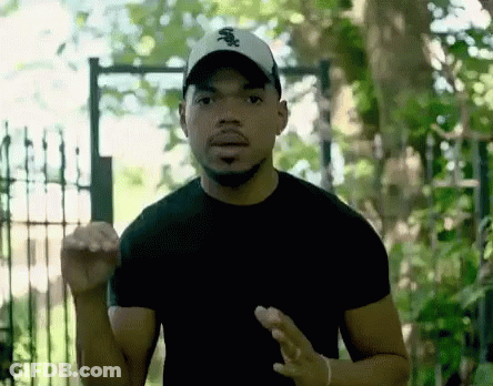 A Man Wearing A White Sox Hat Is Standing In Front Of A Gate GIF