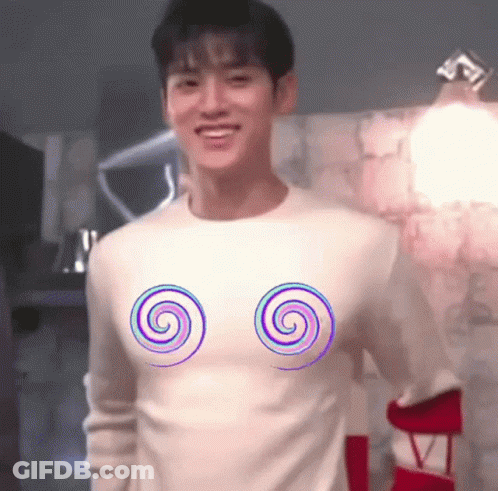 A Man Wearing A White Sweater With Two Spirals On It . GIF