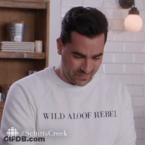 A Man Wearing A White Sweatshirt That Says Wild Aloof Rebel GIF
