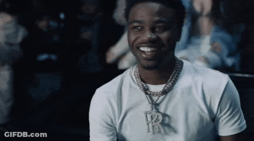 A Man Wearing A White T-Shirt And A Necklace With The Letter R On It GIF