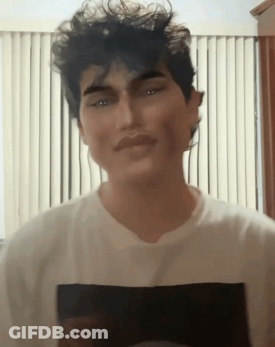 A Man Wearing A White T-Shirt With A Black Square On The Front GIF
