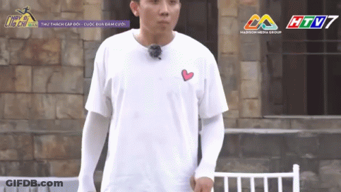 A Man Wearing A White T-Shirt With A Heart On The Chest GIF
