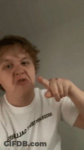 A Man Wearing A White T-Shirt With Russian Writing On It Is Pointing His Finger GIF