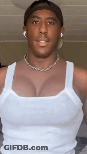 Man In White Tank Top, Hat, Necklace, Earbuds GIF