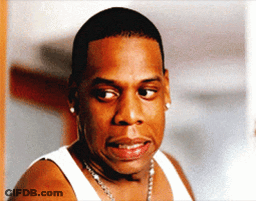 A Man Wearing A White Tank Top And A Necklace GIF