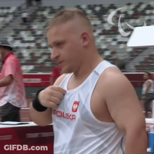 A Man Wearing A White Tank Top With Polska On It GIF