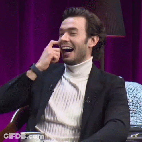 A Man Wearing A White Turtleneck And A Black Jacket Is Smiling GIF