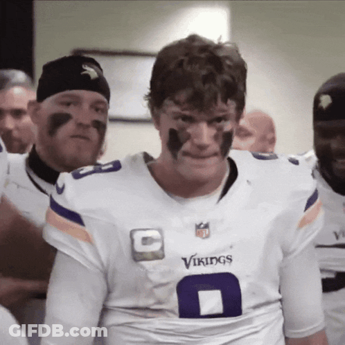 A Man Wearing A White Vikings Jersey With The Number 8 On It GIF