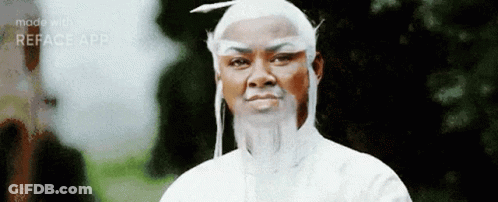 A Man Wearing A White Wig And Beard Is Standing In Front Of Trees . GIF