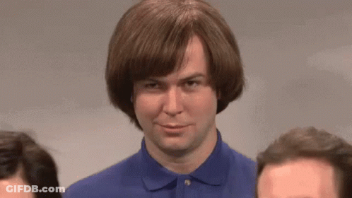 A Man Wearing A Wig And A Blue Shirt Is Standing Next To Two Other Men GIF