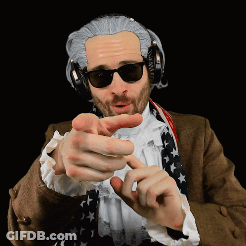 A Man Wearing A Wig And Headphones Points At The Camera GIF