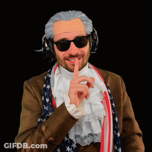 A Man Wearing A Wig And Sunglasses Has His Finger To His Mouth GIF