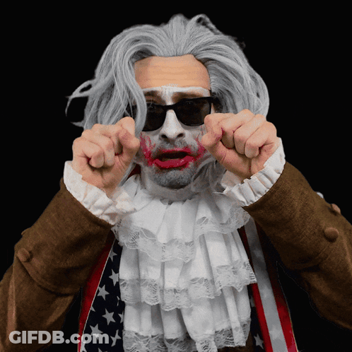 A Man Wearing A Wig And Sunglasses Has Red Lipstick On His Lips GIF