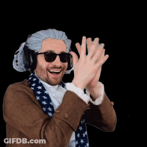 A Man Wearing A Wig And Sunglasses Holds Up His Hands GIF