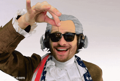 A Man Wearing A Wig And Sunglasses Is Holding A Cherry GIF