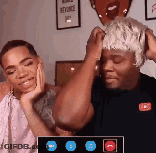 A Man Wearing A Wig Is Talking To Another Man GIF