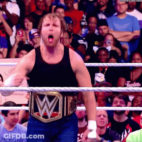 A Man Wearing A Wrestling Belt With The Letter W On It Stands In A Ring GIF