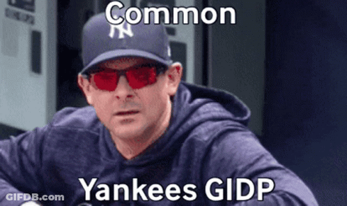 A Man Wearing A Yankees Hat And Red Sunglasses Is Sitting Down . GIF